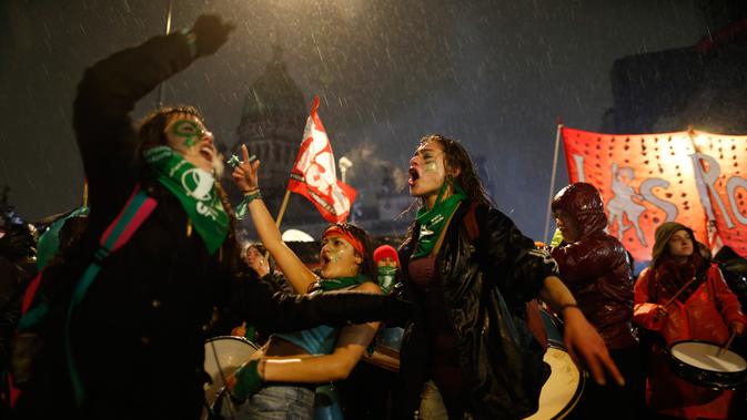 Para wanita menari saat mendukung protes dekriminalisasi aborsi di luar Kongres Nasional di Buenos Aires, Argentina, Rabu (8/8). Senat Argentina menggelar pemungutan suara terkait RUU yang akan melegalkan aborsi. (AP Photo/Natacha Pisarenko)