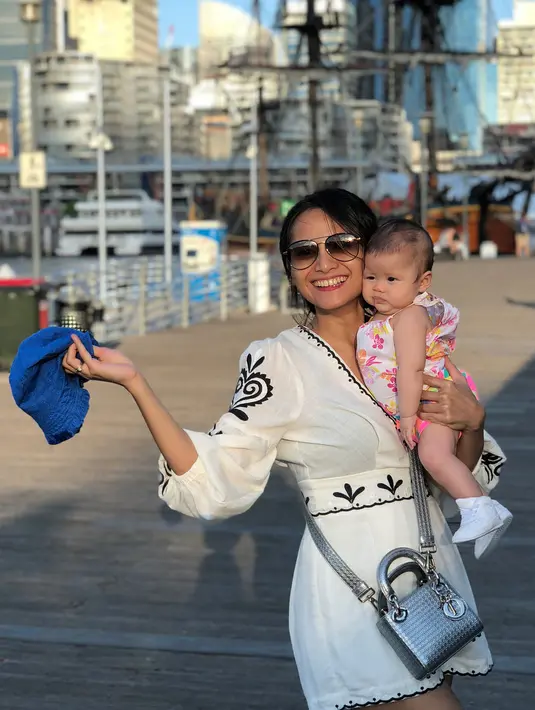 Meski tengah menggendong buah hatinya, Acha kerap tampil kece memakai mini dress berwarna putih dan sunglassesnya. Tak lupa sling bag yang mempermanis penampilannya ini. (Instagram/septriasaacha)