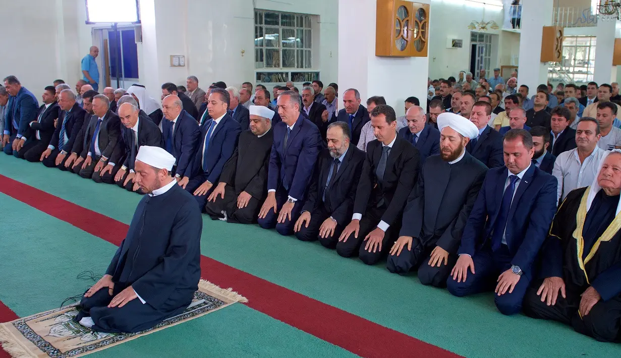 Presiden Suriah, Bashar al-Assad (keempat kanan) melaksanakan salat Idul Adha di Masjid Agung Qara, di wilayah Qalamoun di pinggiran ibukota Suriah Damaskus (1/9). Assad salat didampingi sejumlah pejabat setempat. (AFP Photo/Sana/Handout)