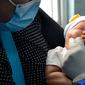 Seorang ibu menggendong bayinya saat petugas kesehatan memberikan vaksin polio di sebuah Pukesmas di Banda Aceh, Aceh, Senin (15/6/2020). Memasuki tatanan normal baru, pelayanan imunisasi anak kembali dibuka setelah sebelumnya sempat terhenti akibat pandemi COVID-19. (CHAIDEER MAHYUDDIN/AFP)