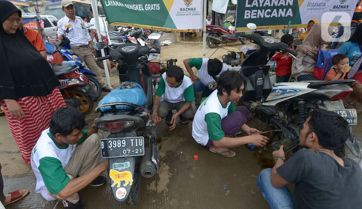 Relawan memperbaiki sepeda motor korban banjir pada layanan bengkel gratis Badan Amil Zakat Nasional (BAZNAS) di Kampung Pulo, Jakarta, Sabtu (4/1/2020). Layanan bengkel gratis ini banyak dimanfaatkan korban banjir untuk memperbaiki sepeda motornya yang sempat terendam. (merdeka.com/Imam Buhori)