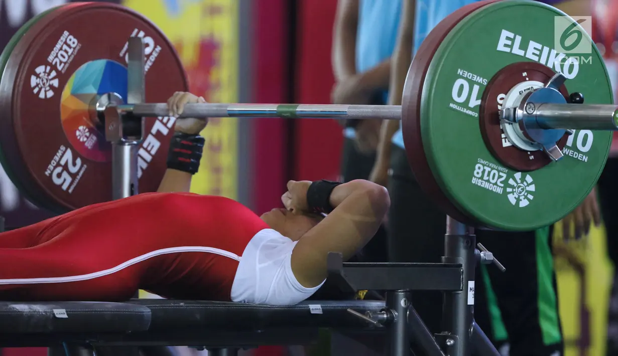 Atlet Para Powerlifting Indonesia, Ni Nengah Widiasih menutup wajah usai gagal melakukan angkatan pada Asian Para Games 2018 di Jakarta, Minggu (7/10). Ni Nengah Widiasih berhasil melakukan total angkatan seberat 97 kg. (Liputan6.com/Helmi Fithriansyah)