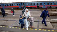 Seorang wanita memegang tangan anak-anak saat turun dari kereta api dari Ukraina di stasiun di Zahony, Hungaria, 8 Maret 2022. PBB mengatakan, serangan gencar Rusia telah memaksa lebih dari 2 juta orang meninggalkan Ukraina. (AP Photo/Darko Vojinovic)