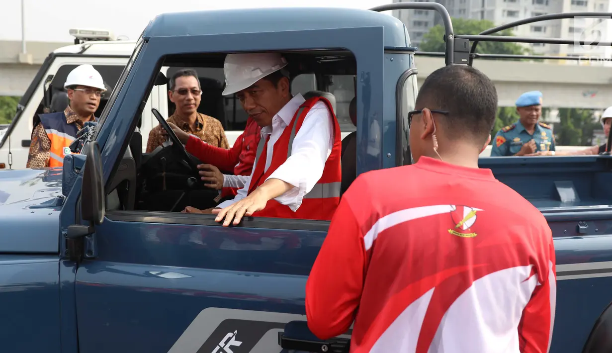 Presiden Joko Widodo (Jokowi) menaiki mobil jip seusai meresmikan jalan Tol Bekasi-Cawang-Kampung Melayu (Becakayu), Jumat (3/11). Bersama rombongan, Jokowi konvoi menjajal ruas tol sepanjang 8,26 km itu. (Liputan6.com/Angga Yuniar)