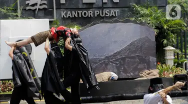 Aktivis lingkungan yang tergabung dalam Koalisi Demokrasi Energi menggelar aksi teatrikal saat unjuk rasa di depan kantor pusat PLN, Jakarta, Kamis (26/10/2023). (Liputan6.com/Herman Zakharia)