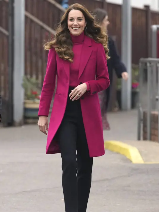 Kate Middleton, Duchess of Cambridge tersenyum saat tiba untuk berkunjung ke Nower Hill High School di Harrow, London utara (24/11/2021). Ia mengikuti pelajaran sains yang mempelajari ilmu saraf dan pentingnya perkembangan anak usia dini bersama para siswa. (AFP/Pool/Kirsty Wigglesworth)