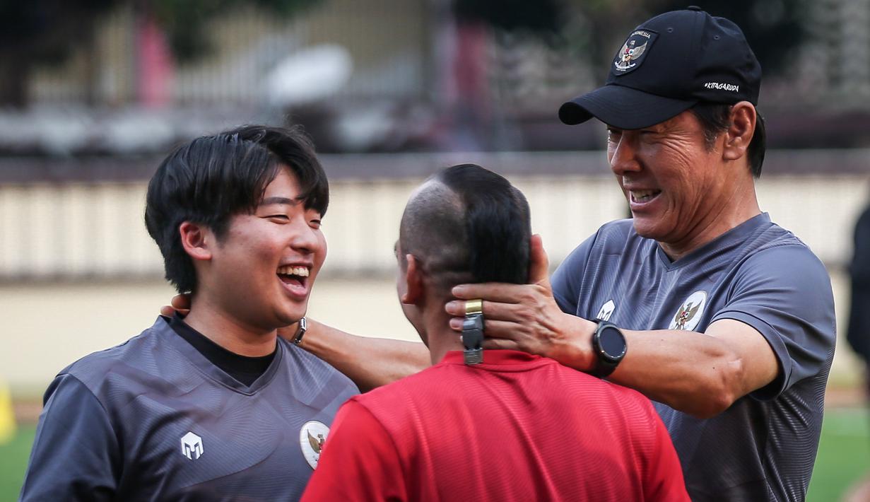 <p>Pelatih Kepala Timnas Indonesia, Shin Tae-yong (kanan) bercanda dengan pemainnya, Riko Simanjuntak (tengah) dan penerjemahnya, Jeong Seok-seo saat latihan perdana Timnas Indonesia yang berlangsung di Stadion PTIK, Jakarta, Senin (20/03/2023) sore WIB. Skuad Garuda rencananya akan melakoni laga FIFA Match Day melawan Burundi pada 25 dan 28 Maret 2023 di Stadion Patriot Candrabhaga, Bekasi. (Bola.com/Bagaskara Lazuardi)</p>