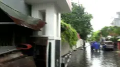 Petugas BPBD mengevakuasi tubuh Suryati yang tewas tersengat listrik dipinggir jalan. 