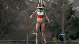 Seorang aktivis dari organisasi hak-hak perempuan Femen melakukan aksi bergelantungan dari sebuah jembatan di Paris, Prancis, Kamis (28/1). Mereka menggelar protes atas kunjungan Presiden Iran, Hassan Rouhani ke Paris. (REUTERS/Charles Platiau)