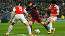 Penyerang Barcelona, Lionel Messi (tengah) berusaha melewati dua pemain Arsenal pada leg kedua 16 besar liga champions di stadion Nou Camp, Spanyol (17/3). Barcelona menang atas Arsenal dengan skor 3-1. (Reuters/Albert Gea)