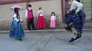 Seorang gadis mengenakan masker sebagai tindakan pencegahan terhadap virus corona bermain saat dia mengunjungi anggota keluarganya untuk merayakan liburan Chuseok, Hari Thanksgiving versi Korea, di Istana Gyeongbok di Seoul, Korea Selatan, Rabu (22/9/2021). ( AP Photo/Ahn Young-joon)