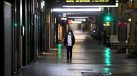 Seorang pria berjalan di jalan yang sepi selama aturan jam malam di Melbourne, pada Selasa (17/8/2021). Kota terbesar kedua di Australia itu memberlakukan pembatasan tinggal di rumah pada pukul 9 malam hingga 5 pagi untuK meredam lonjakan Covid-19 varian Delta. (William WEST/AFP)