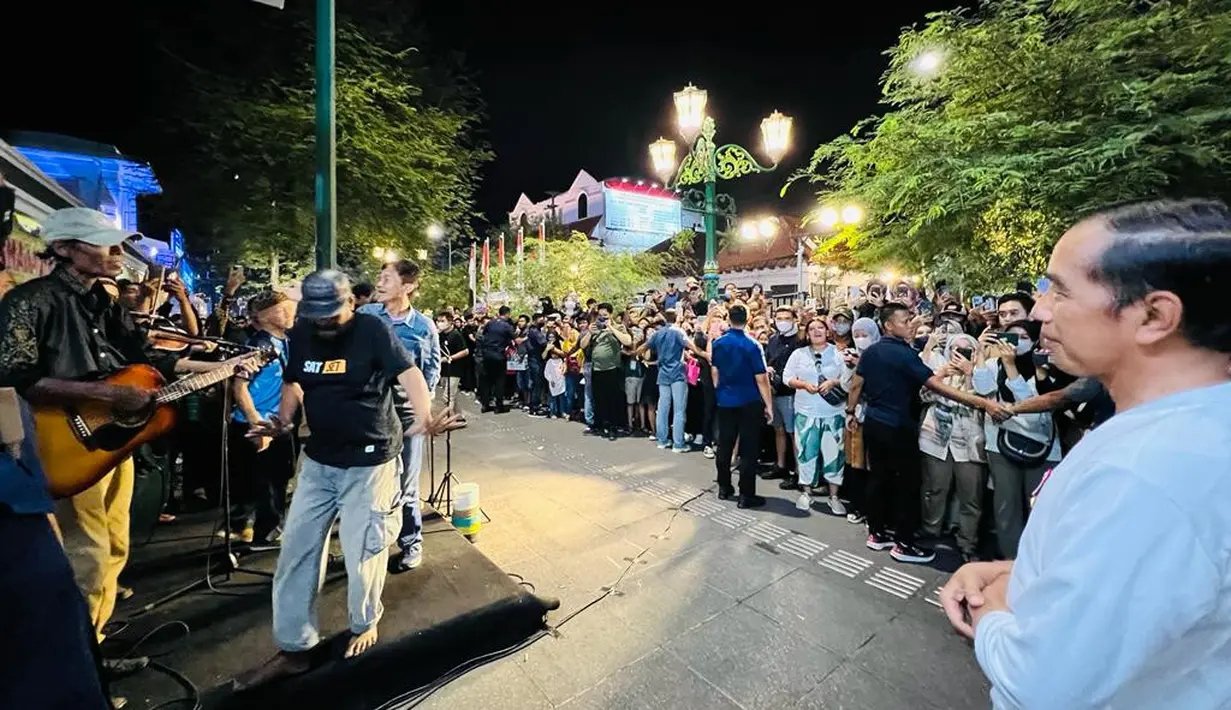 Presiden Joko Widodo saat menikmati nyanyian dari seniman musik jalanan di kawasan Malioboro, Daerah Istimewa Yogyakarta pada Sabtu malam, 15 Oktober 2022. “Saya menikmati denyut kehidupan masyarakat malam hari di Yogyakarta, semalam. Di Malioboro, saya bertemu warga, wisatawan, para pedagang asongan, dan tak lupa mendengar nyanyian dari seniman musik jalanan,” ucap Presiden dalam akun instagram @jokowi. (Foto: Laily Rachev - Biro Pers Sekretariat Presiden)