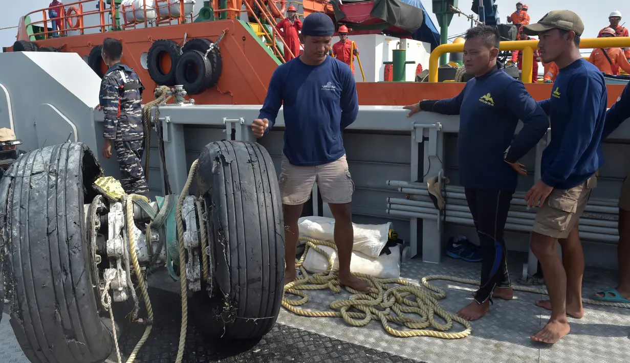 Para penyelam dari TNI Angkatan Laut melihat kondisi roda pesawat Lion Air PK-LQP dengan nomor penerbangan JT 610 yang berhasil diangkat dari perairan Tanjung Karawang, Jawa Barat, Jumat (2/11). (ADEK BERRY/AFP)