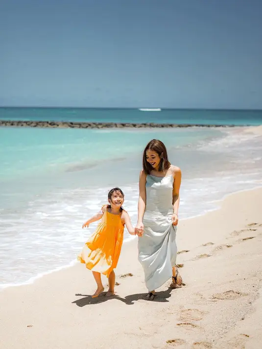 Bisa jadi inspirasi outfit kompak ibu-anak saat ke pantai, Gisel dan Gempi pilih spaghetti strap dress warna cerah. [@gisel_la]