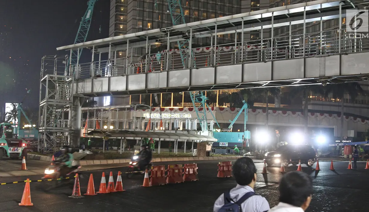 Suasana proses pembongkaran Jembatan Penyeberangan Orang (JPO) di Kawasan Bundaran HI, Jakarta,  Jakarta, Senin (30/7/2018) malam. Pembongkaran JPO ini juga terkait upaya mempercantik ibu kota jelang Asian games 2018. (Liputan6.com/Herman Zakharia)