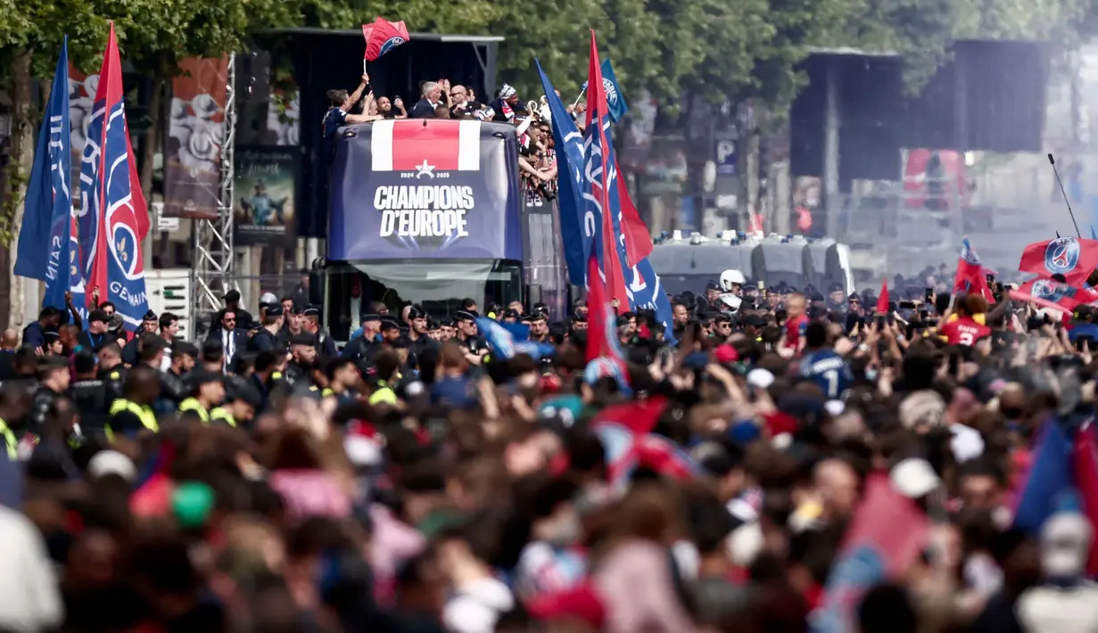 Dari atas bus terbuka, para pemain menyapa para pendukung sambil memamerkan trofi Liga Champions. (Thibaud MORITZ/AFP)