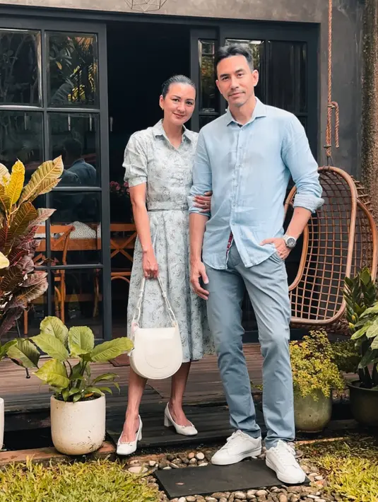 Donna Agnesia dan Darius Sinatria kompak mengenakan baju bernuansa baby blue. Donna mengenakan long dress baby blue bermotif model kerah dipadukan heels putih serasi dengan handbagnya. [@dagnesia]