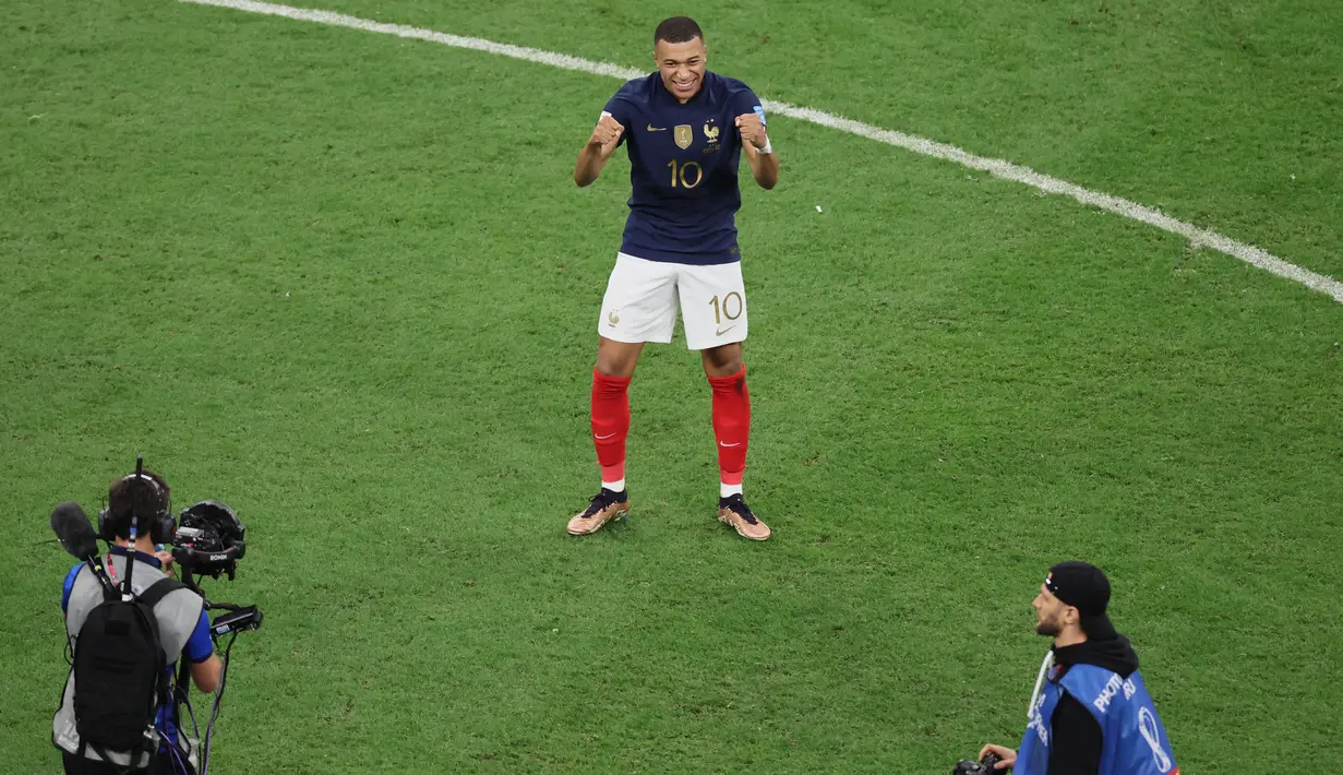Penyerang Prancis Kylian Mbappe merayakan kemenangan timnya atas Inggris pada akhir laga perempat final Piala Dunia 2022 di Al Bayt Stadium, Minggu (11/12/2022) dini hari WIB. Mbappe tampak tertawa lepas usai penyerang timnas Inggris, Harry Kane gagal mengeksekusi penalti keduanya. (JACK GUEZ / AFP)