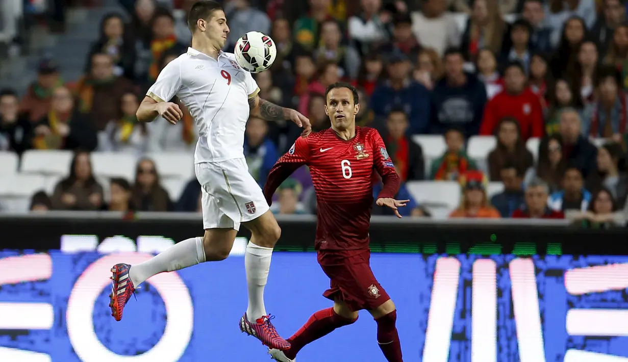 Penyerang Serbia, Aleksandar Mitrovic mengontrol bola dari kejaran bek Portugal Ricardo Carvalho pada kualifikasi Piala Eropa 2016 di stadion Luz, Lisbon, Minggu (29/3/2015). Portugal menang 2-1 atas Georgia. (REUTERS/Rafael Marchante)