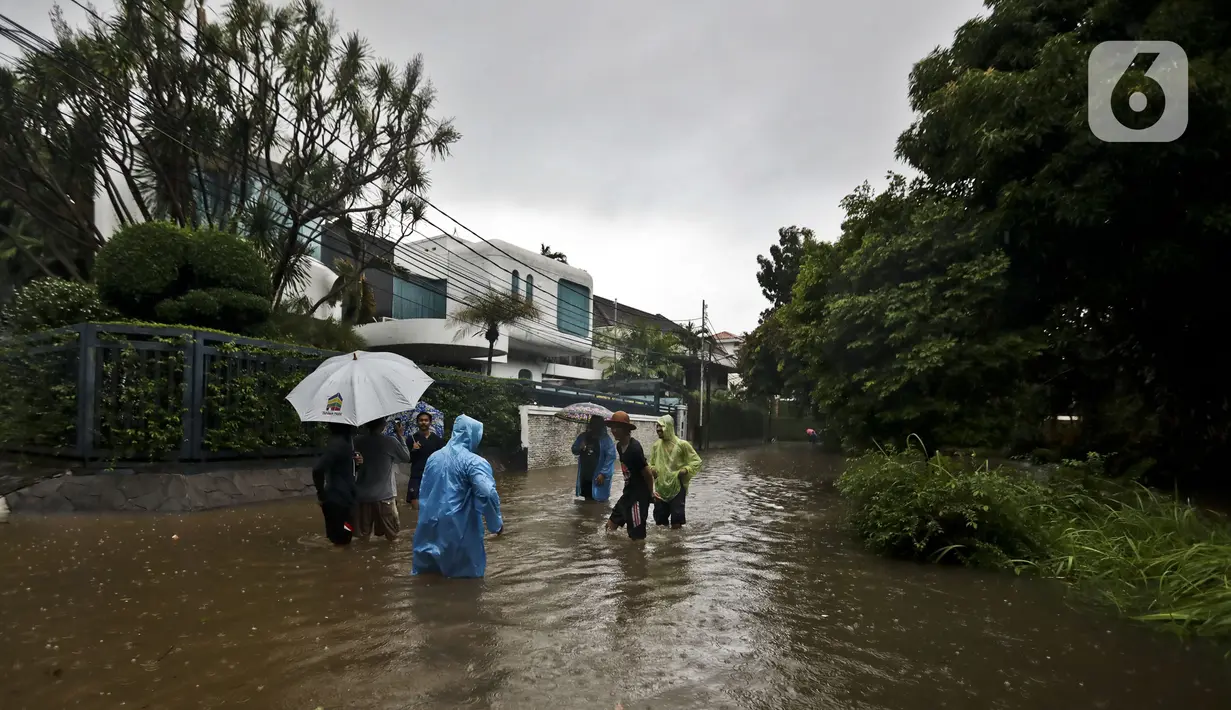 Warga beraktivitas diarea lingkungannya yang tergenang banjir di Jalan Hang Lekir, Kebayoran Lama, Jakarta Selatan, Rabu (1/1/2020). Banjir tersebut disebabkan karena tingginya intensitas hujan yang mengguyur sejak Selasa (31/12/2019). (Liputan6.com/Johan Tallo)