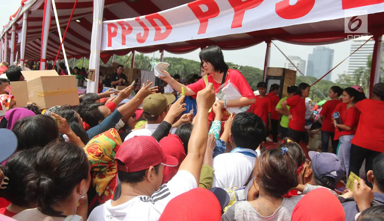 Panitia memberikan kaos kaki gratis dalam acara "Untukmu Indonesia" di lapangan Monas, Jakarta, Sabtu (28/4). Acara ini dimeriahkan oleh sejumlah kegiatan seperti pertunjukkan seni dan khitanan massal. (Liputan6.com/Arya Manggala)