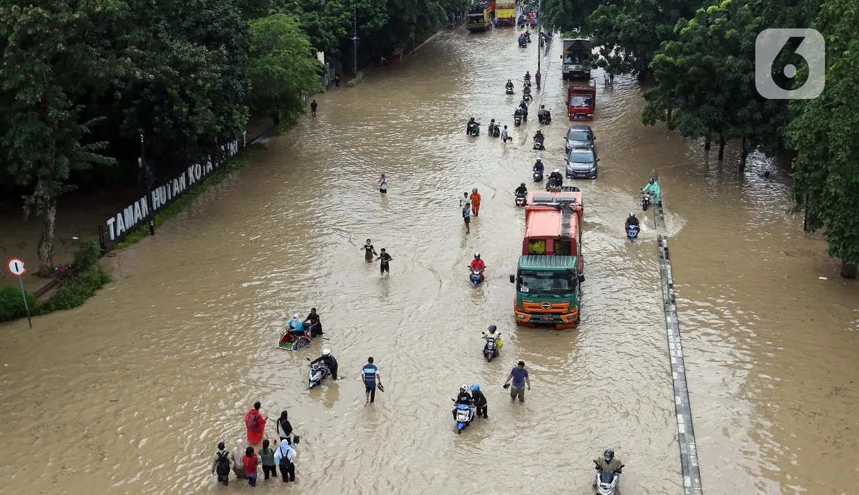 Sejumlah pengendara motor dan warga menerobos genangan air di jalan Sultan Agung , kota Bekasi, Jawa Barat, Selasa (4/3/2025). (Liputan6.com/Herman Zakharia)