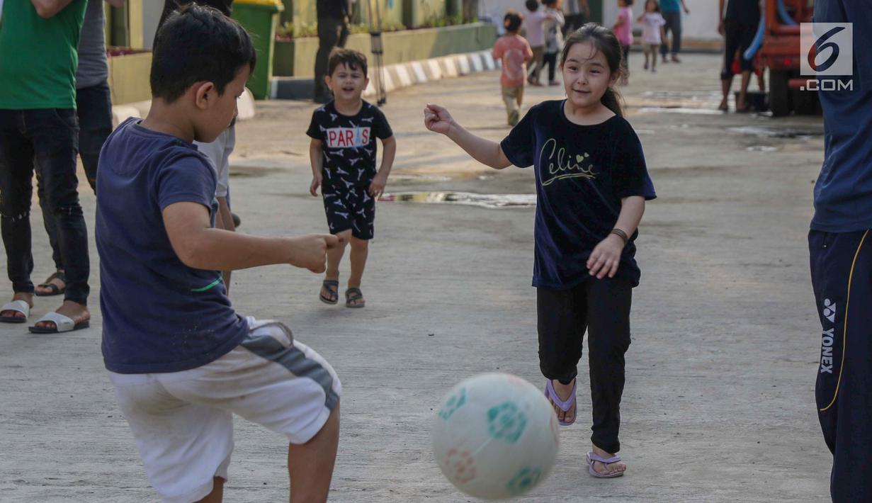 Anak-anak pencari suaka bermain sepak bola di halaman bekas Markas Kodim di Kalideres, Jakarta, Selasa (16/7/2019). Sebelumnya, para pencari suaka dari berbagai negara berkonfilk ini tinggal di pinggir jalan dan trotoar di kawasan Kebon Sirih, Jakarta. (Liputan6.com/Helmi Fithriansyah)