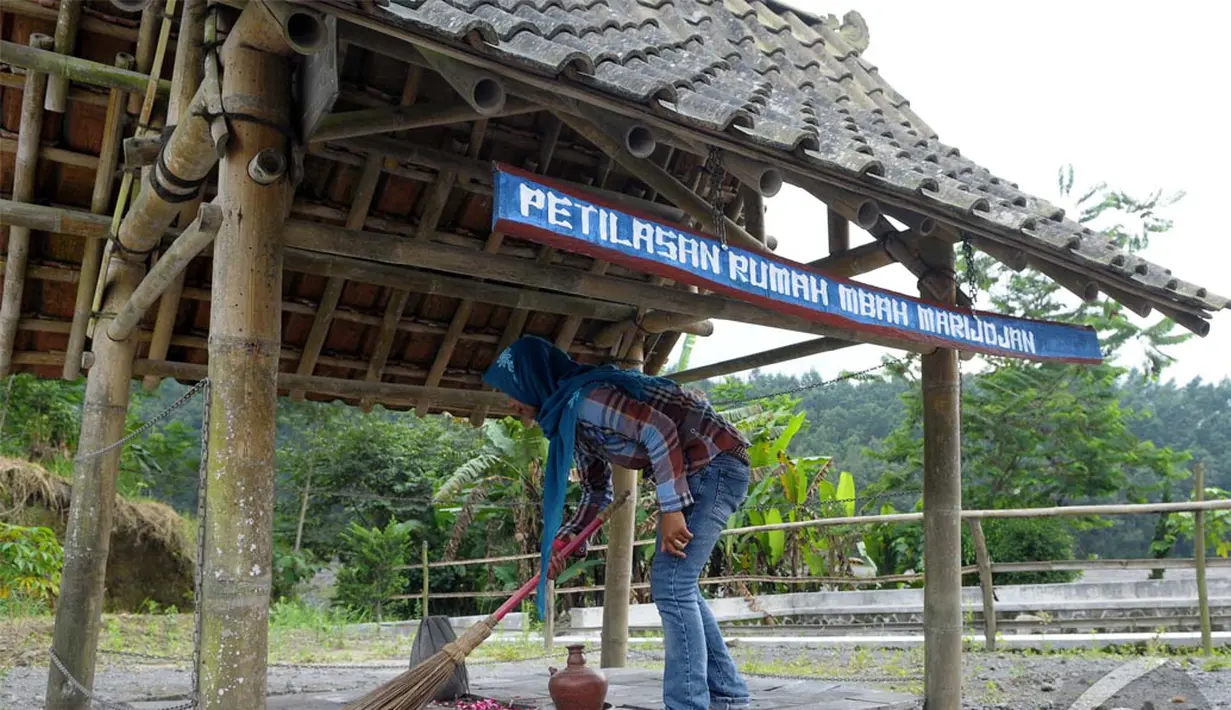 Seorang wanita sedang membersihkan Makam Mbah Maridjan yang menjadi objek wisata, Yogyakarta, Senin (12/05/2014) (Liputan6.com/Andrian M Tunay).