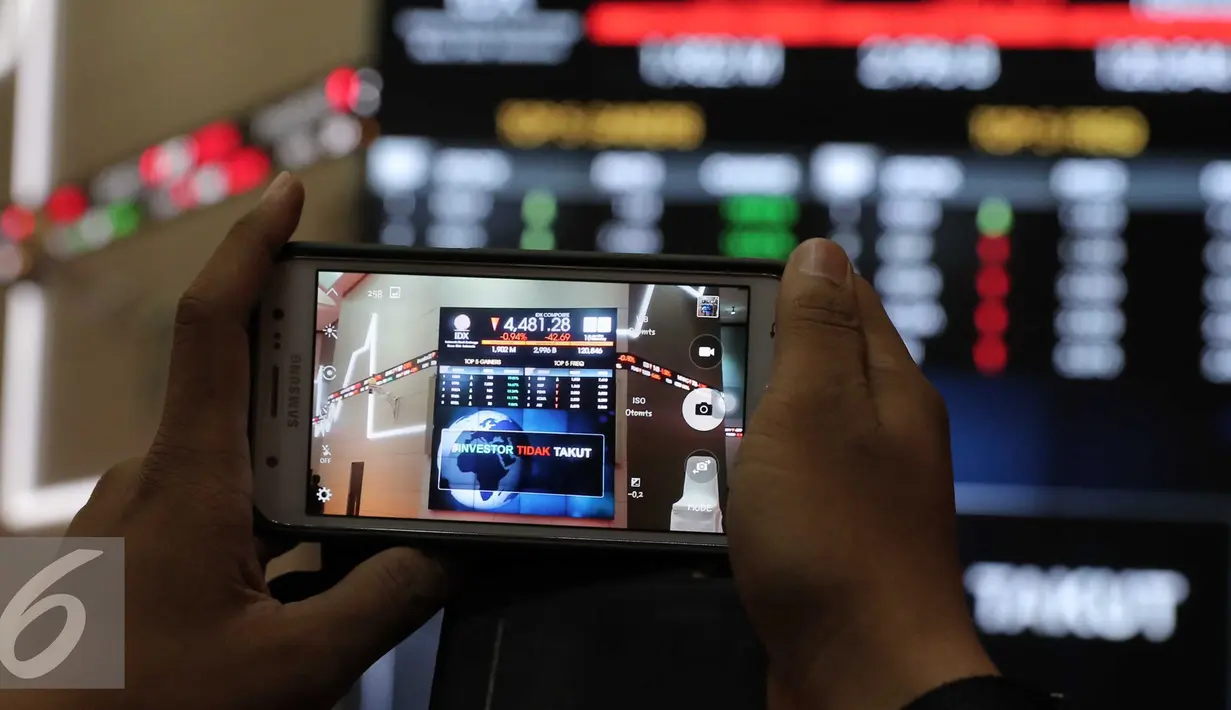 Pengunjung mengabadikan gambar bertuliskan #investor tidak takut di Bursa Efek Indonesia, Jakarta, Senin (18/1). Direktur utama BEI Tito menjelaskan tidak terjadi pengaruh besar pasca teror terhadap perdagangan di BEI. (Liputan6.com/Angga Yuniar)