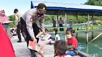 Anak-anak Pulau Lutungan saat menerima buku bacaan dari Kapolsek Baolan, Tolitoli, Iptu H Siswanto, Kamis (6/8/2020). Buku yang dibagikan itu berasal dari perpustakaan daerah yang dipinjam langsung oleh kapolsek. (Foto: Humas Polres Tolitoli).