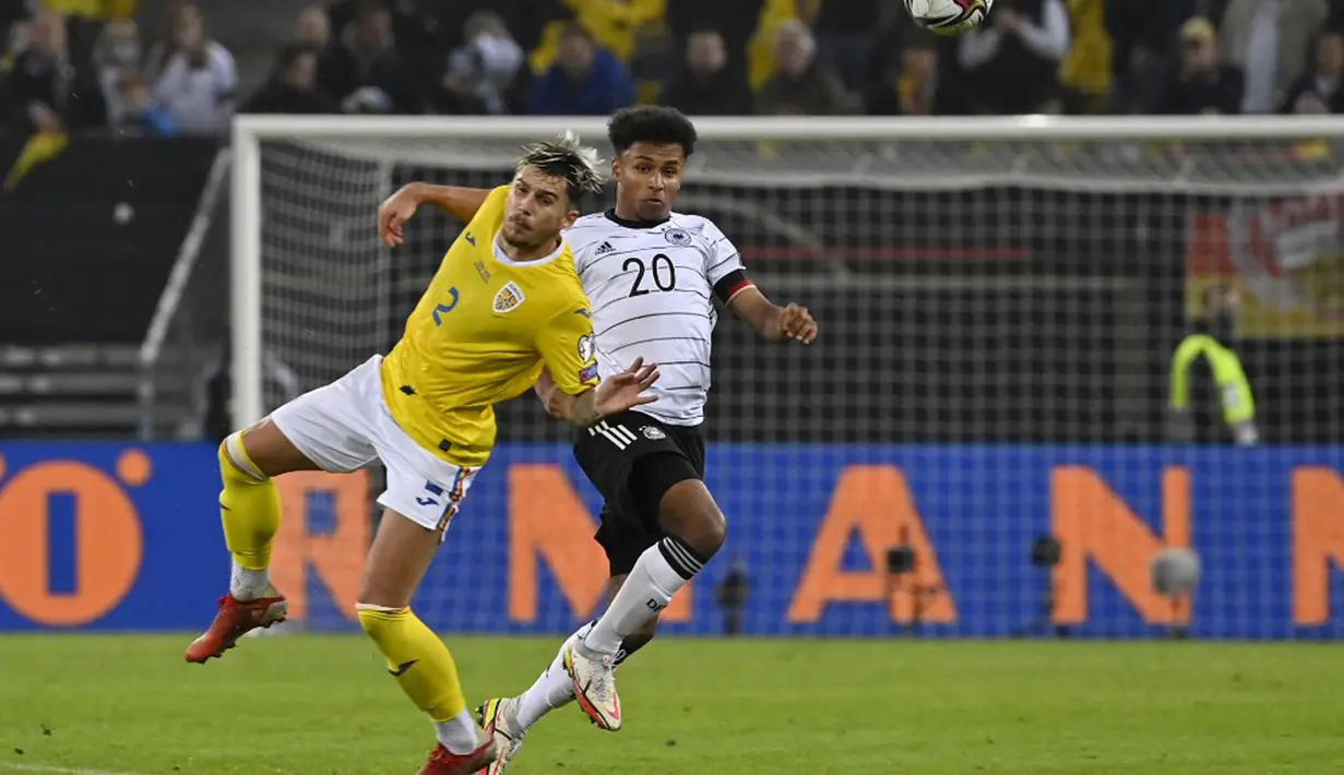 Pemain Rumania Andrei Ratiu (kiri) berebut bola dengan pemain Jerman Karim Adeyemi pada pertandingan Grup J kualifikasi Piala Dunia Qatar 2022 di Hamburg, Jerman, 8 Oktober 2021. Jerman menang 2-1. (John MACDOUGALL/AFP)