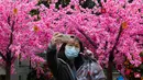 Seorang perempuan berswafoto di depan dekorasi untuk merayakan Tahun Baru Imlek di Hong Kong, Minggu (30/1/2022). Tahun Baru China atau Imlek jatuh pada 1 Februari (AP Photo/Vincent Yu)