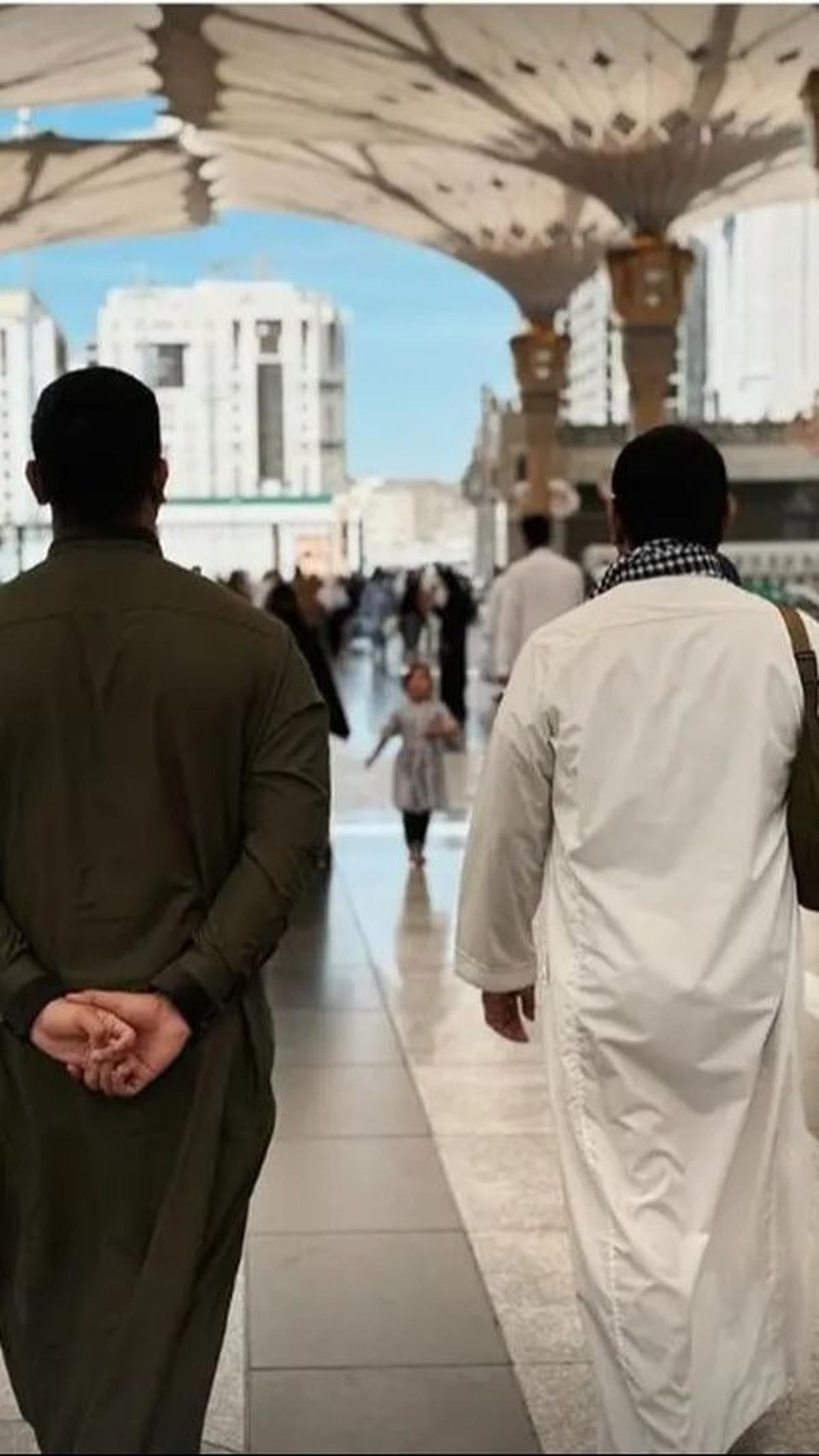 Potret dari belakang saat mereka berjalan bersama menunjukkan kehangatan dan kebersamaan antara ayah dan anak.
