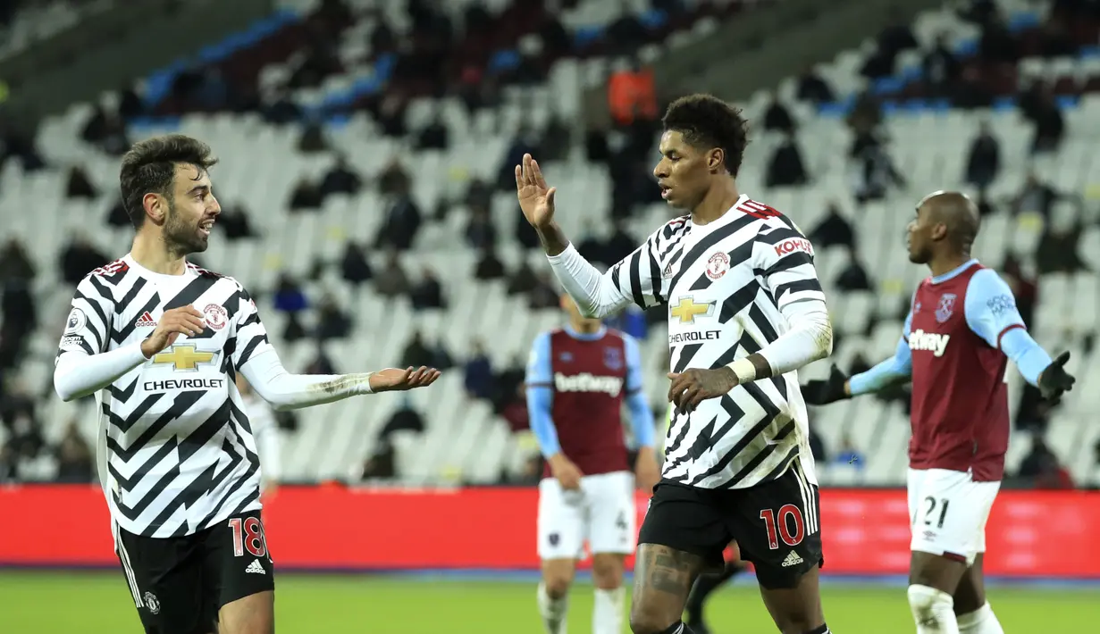 Penyerang Manchester United, Marcus Rashford (kanan) berselebrasi dengan rekannya Bruno Fernandes pada pertandingan lanjutan Liga Inggris di stadion London di London, Inggris, Minggu (6/12/2020). MU menang 3-1 atas West Ham. (Adam Davy / Pool via AP)