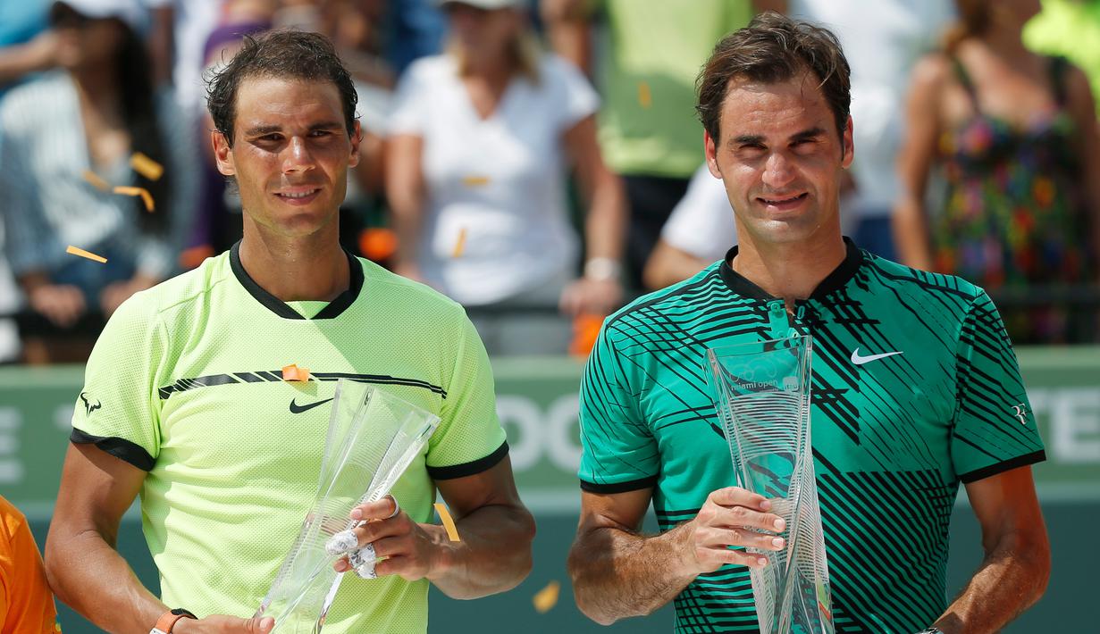 Roger Federer (kanan) dan Rafael Nadal berpose dengan trofinya di Crandon Park, Florida (2/4). Bagi Federer, ini adalah titel ketiganya di Miami atau yang pertama dalam 11 tahun usai memenanginya di 2005 dan 2006. (AP Photo/Wilfredo Lee)