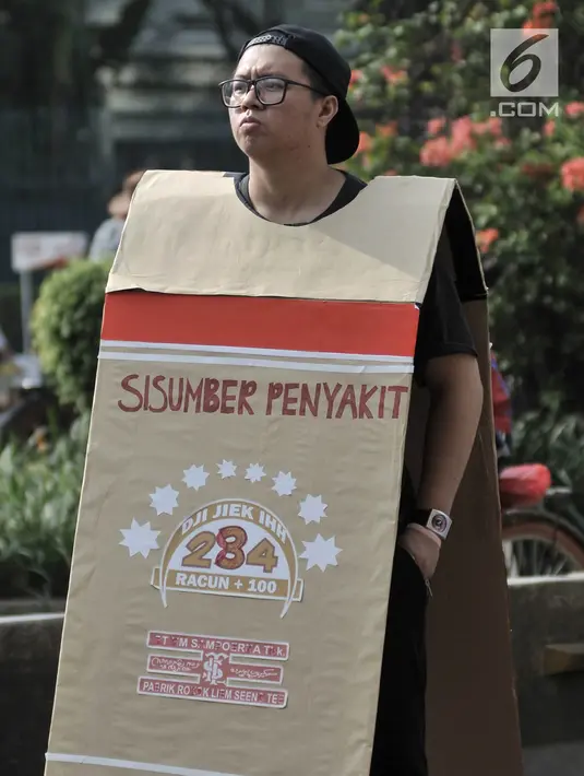 Mahasiswa memakai kardus bertuliskan bahaya merokok di car free day (CFD), Jakarta, Minggu (6/5). Dalam aksinya, mahasiswa menolak RUU Pertembakauan. Dalam aksinya, mahasiswa menolak RUU Pertembakauan. (Merdeka.com/Iqbal Nugroho)