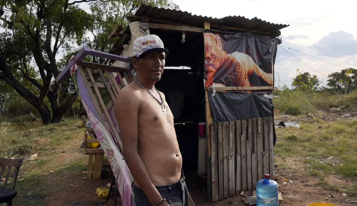Seorang warga menjaga gubuknya selama kebakaran semak di lingkungan Banco San Miguel di Asuncion, Paraguay (18/1/2022). Cuaca kering yang tidak biasa memicu kebakaran di lapangan terbuka, peternakan pribadi, dan lahan publik sekitar kota. (AP Photo/Jorge Saenz)