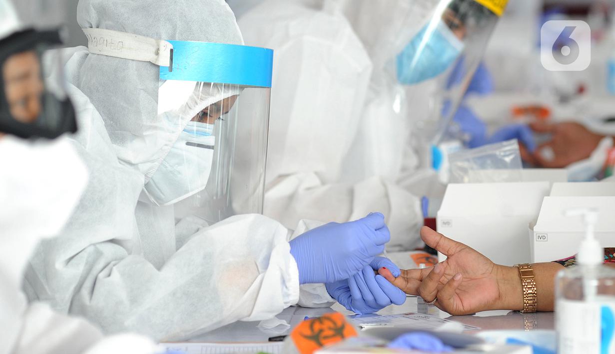 Petugas medis memeriksa warga saat rapid test oleh BIN di Lapangan Kantor Kecamatan Pamulang, Tangerang Selatan, Banten, Kamis (2/7/2020). BIN menggelar rapid test gratis terhadap 800 warga Pamulang untuk memutus mata rantai penyebaran virus corona COVID-19. (merdeka.com/Arie Basuki)