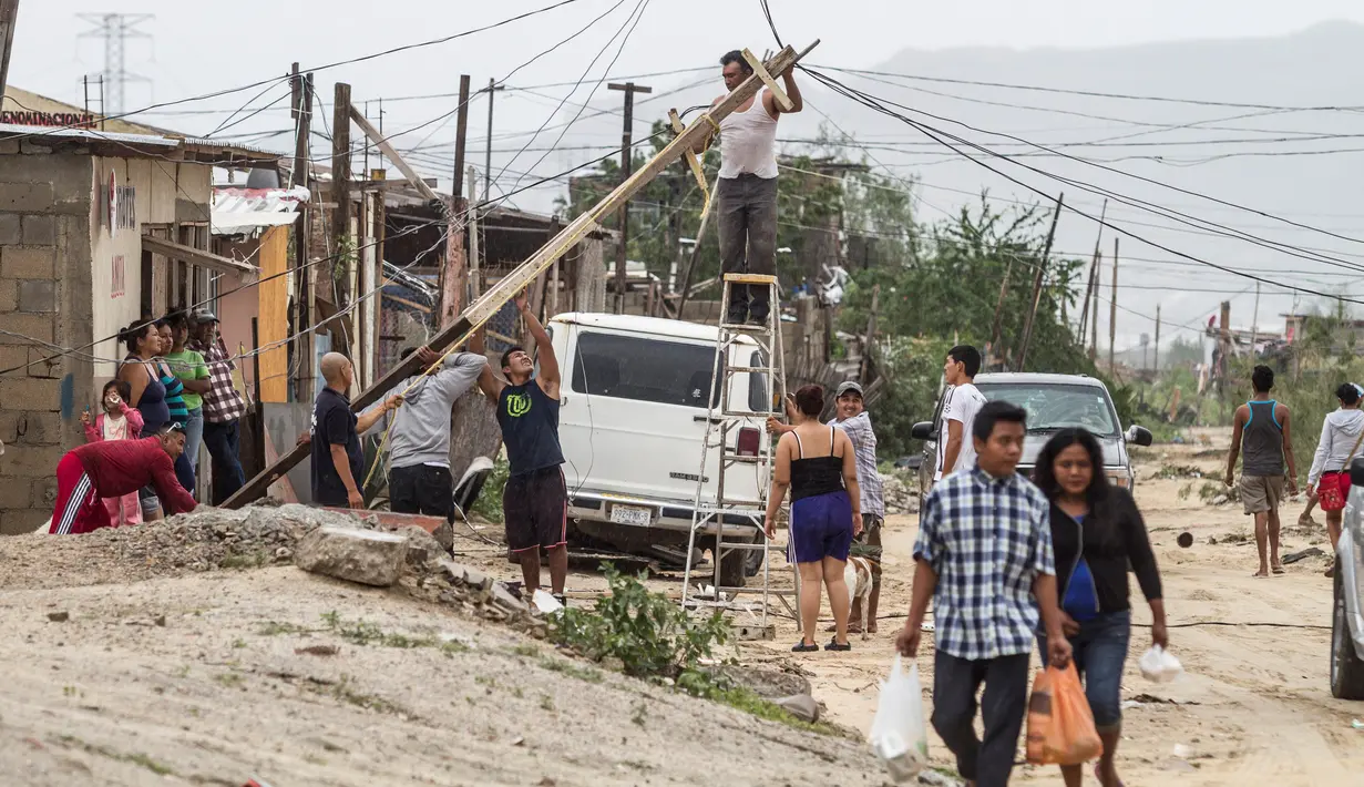 Warga memperbaiki instalasi listrik yang putus setelah hantaman Badai Newton di Los Cabos, Meksiko, Selasa (6/9). Menurut otoritas berwenang, Badai Newton telah mengakibatkan dua orang meninggal dan tiga lainnya hilang. (REUTERS/Fernando Castillo)