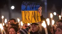 Seorang wanita memegang spanduk saat demonstrasi untuk Ukraina yang diselenggarakan oleh Greenpeace di Heroes Square, Budapest, Hungaria, 9 Maret 2022. Lebih dari 1,5 juta orang telah menyeberang dari Ukraina ke negara-negara tetangga. (AP Photo/Anna Szilagyi)