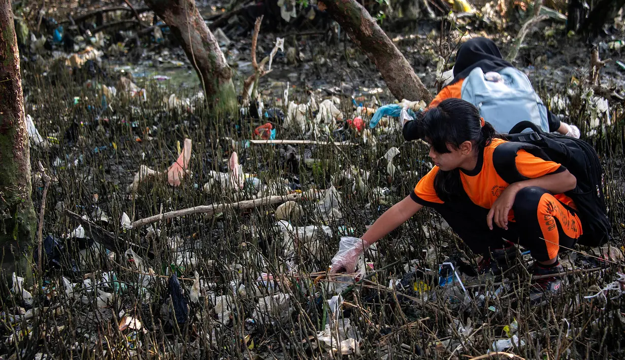 Seorang anak membersihkan sampah pada kegiatan World Cleanup Day 2019  di kawasan pantai di Surabaya, Sabtu (21/9/2019). Aksi bersih-bersih sampah yang digelar secara serentak di 157 negara ini mengajak masyarakat untuk bijak menggunakan plastik.  (JUNI KRISWANTO / AFP)