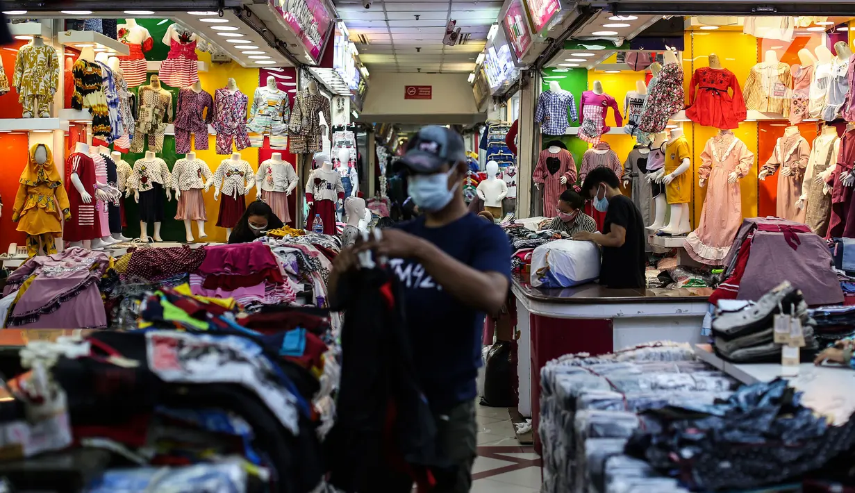 Pedagang pakaian menata dagangannya di Pasar Tanah Abang, Jakarta, Selasa (27/7/2021). Pasar Tanah Abang yang kembali dibuka mulai Senin (26/7) mewajibkan pengunjung serta pedagang menunjukkan sertifikat vaksinasi COVID-19 untuk masuk ke pasar. (Liputan6.com/Johan Tallo)