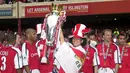 Gelandang Arsenal, Fredrik Ljungberg mengangkat trofi dalam perayaan gelar juara Liga Inggris 2001/2002 usai laga menghadapi Everton di Highbury Stadium, London (11/5/2002). Arsenal menjadi klub kedua yang mampu menyandingkan raihan trofi Liga Inggris dengan Piala FA dalam satu musim di Era Premier League. The Gunners tercatat pernah dua kali meraih trofi Liga Inggris dan Piala FA dalam satu musim, yaitu pada 1997/1998 dan 2001/2002. (AFP/Nicolas Asfouri)