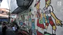 Anak sekolah melintas di depan lukisan tembok atau mural yang menghiasi gang di RT 13 RW 06, Jembatan Lima, Jakarta, Kamis (10/1). Pembuatan mural itu dimaksudkan agar lingkungan menjadi lebih tertata dan indah. (Merdeka.com/Iqbal Nugroho)