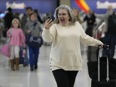 Marissa Colleluori berbicara dengan cucunya melalui FaceTime sebelum menaiki pesawat ke Buffalo untuk liburan Thanksgiving di Bandara Internasional Nashville, Selasa, 21 November 2023. (AP Photo/George Walker IV)