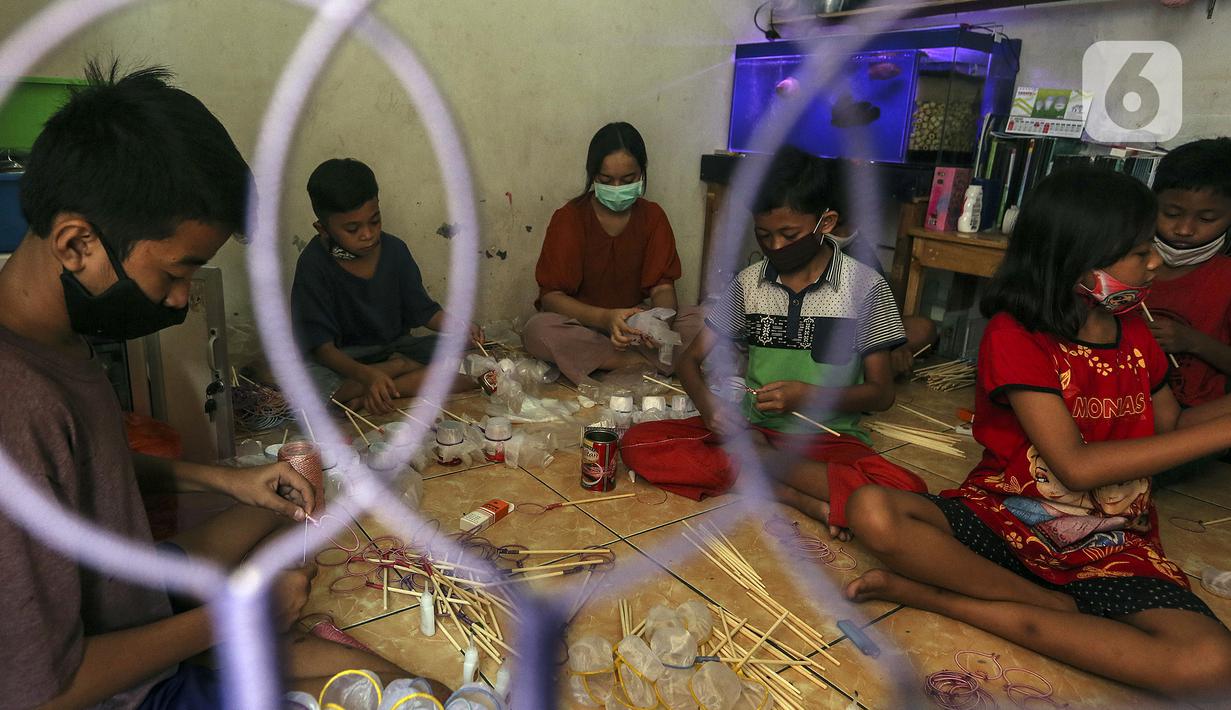 Anak-anak membuat serokan ikan cupang di rumah kontrakan Udin, Sukabumi Selatan, Jakarta Barat, Selasa (22/12/2020). Musim ikan cupang saat ini dimanfaatkan oleh Udin untuk membuat dan menjual serokan ikan seharga Rp 4.000. (Liputan6.com/Johan Tallo)