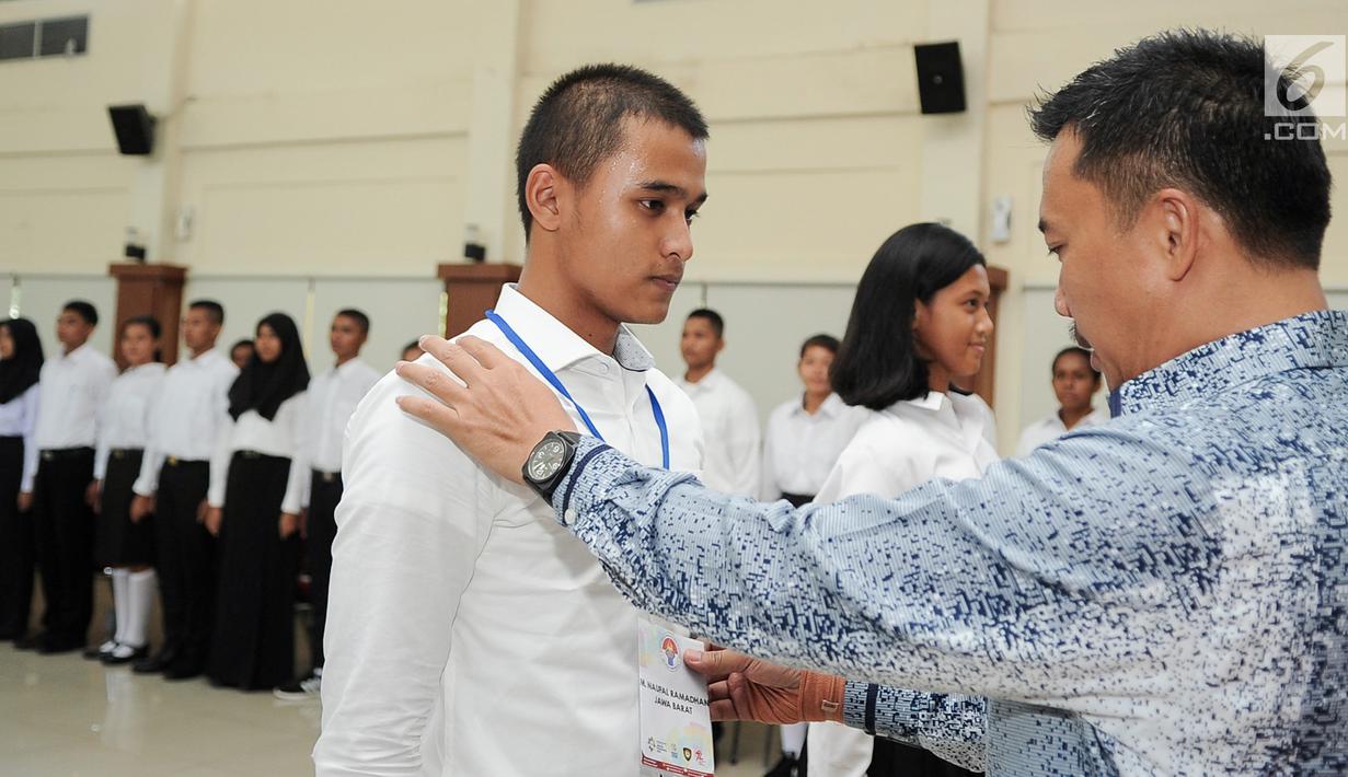 Menpora Imam Nahrawi mengalungkan tanda pengenal saat pembukaan Pusdiklat Paskibraka Nasional 2017 di PP-PON Cibubur, Jakarta, Rabu (26/7). Sebanyak 68 putra dan putri terbaik dari 34 Provinsi di Indonesia menjalani Pusdiklat. (Liputan6.com/Yoppy Renato)