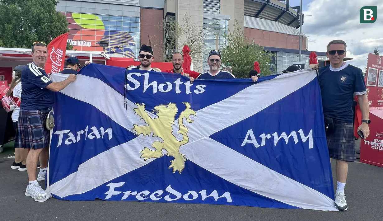 Suporter Skotlandia membentangkan bendera bertuliskan "Tartan Army" di area fanzone Gillette Stadium, Foxborough, Amerika Serikat, Jumat (19/6/2026), menjelang laga melawan Maroko pada Piala Dunia 2026. Bendera tersebut menjadi simbol kebanggaan dan dukungan Tartan Army kepada Timnas Skotlandia. (KLY Sports/Hery Kurniawan)