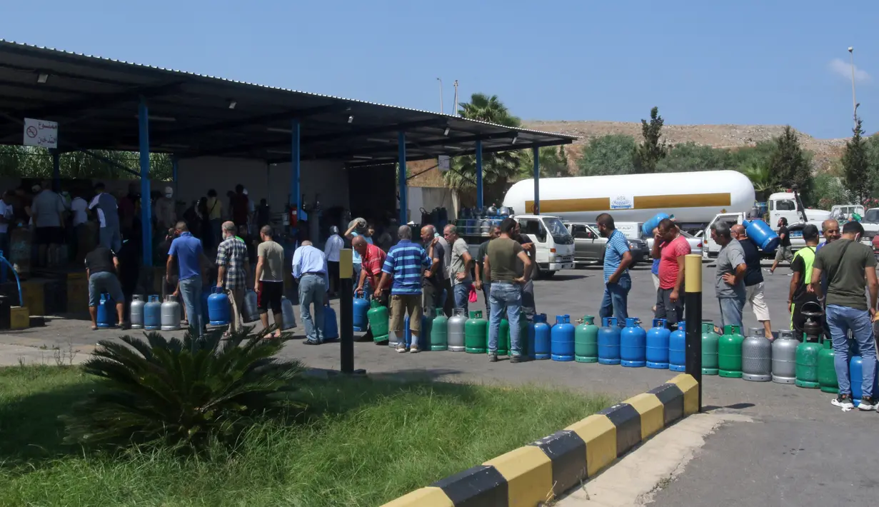 Warga Lebanon menunggu untuk mengisi tabung gas di tengah krisis ekonomi yang semakin parah di kota selatan Sidon, Selasa (10/8/2021). Krisis ekonomi yang dihadapi Lebanon diakui Bank Dunia sebagai salah satu yang terburuk di planet ini sejak pertengahan abad ke-19. (Mahmoud ZAYYAT/AFP)